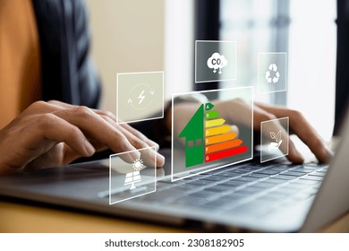 Home improvement concept, Hand of businessman using laptop with energy efficiency rating, ecological and bioenergetic house, efficiency scale. - Powered by Shutterstock