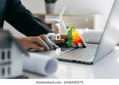 Home improvement concept, Hand of businessman using laptop with energy efficiency rating, ecological and bioenergetic house, efficiency scale. - Powered by Shutterstock