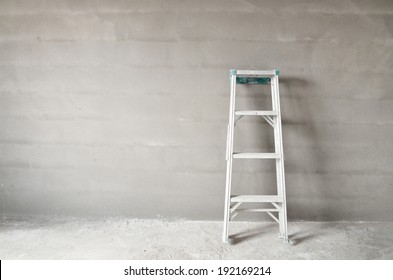 Home Improvement Concept With Ladder And Plaster Wall