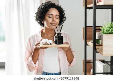 home improvement, decoration and people concept - happy smiling woman smelling aroma reed diffuser on board with cotton flower at shelf - Shutterstock ID 2079119848
