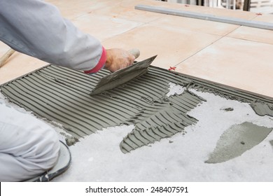 Home Improvement, Renovation - Handyman Laying Tile, Trowel With Mortar