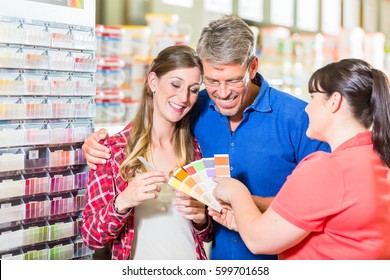 Home Improvement Store Clerk Counseling Customers About Choice Of Colour For Wall Paint