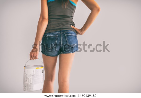 Home improvement woman\
choosing new colors painting walls of bedroom apartment holding\
paint bucket.