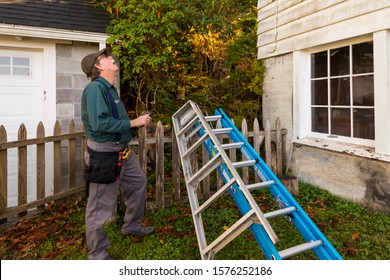 Home Inspector Looks Up At Roof Of A Home
