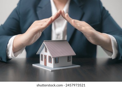 Home insurance concept. Homeowner entrusted the concept of protecting their property to the insurance agent's hand, ensuring their house and finances were secured through a mortgage insurance plan. - Powered by Shutterstock