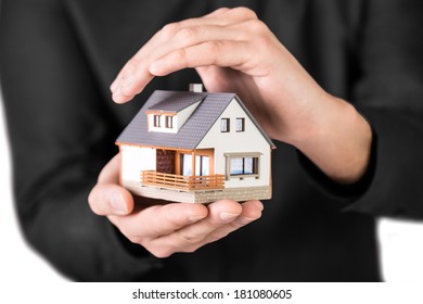 Home Insurance Concept. House Protection Concept. Beautiful House In Mans Hands