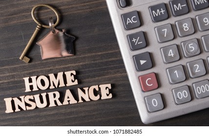Home Insurance with house key and calculator on wooden table top - Shutterstock ID 1071882485