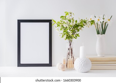 Home Interior With Decor Elements. Mockup With A Black Frame, Spring Flowers In A Vase On A Light Background