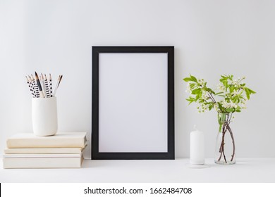 Home Interior With Decor Elements. Mockup With A Black Frame, Spring Flowers In A Vase On A Light Background