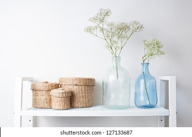 Home Interior Decoration: The Branches In Vintage Bottles And Baskets On White Shelves