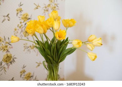 Home interior design, bouquet of yellow tulips on wooden stool