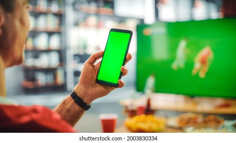 At Home Joyful Soccer Fans Sit on a Couch Watch Green Screen Chroma Key Screen. Friends Cheer for Favourtite Football Sports Team to Win Championship. Over the Shoulder - Powered by Shutterstock