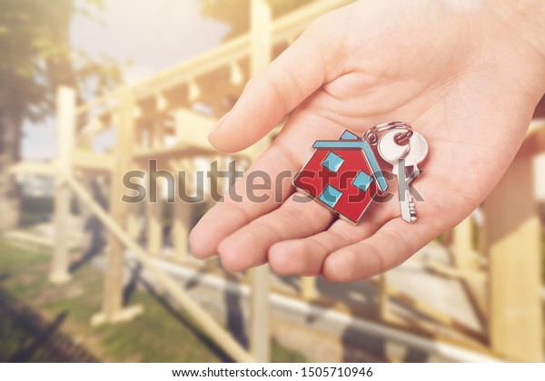 Home key in house keychain on woman/ man/ human\
hand support offering security protection awareness concept:\
Insurance agent in white shirt holding happy residential key lock/\
unlock insure habitat