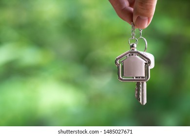 Home key with house keyring hanging with white wall background, copy space - Powered by Shutterstock