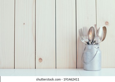 Home Kitchen Decor: Vintage Cutlery, Spoons And Forks In Zinc Can On A Wooden Board Background , Cozy Arrangement Retro Style, Soft Pastel Colors.