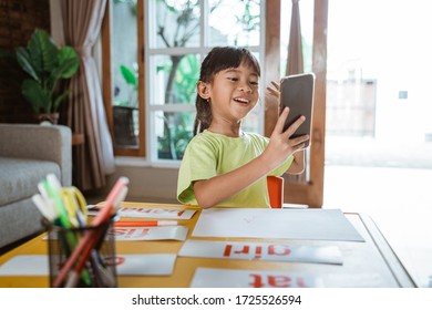 home learning with mobile phone. kid homeschooling studying online