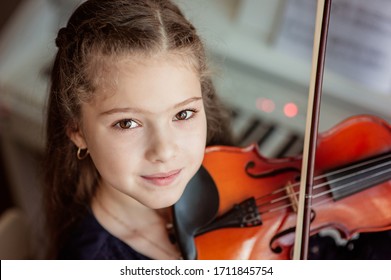 Home lesson for a girl playing the violin. The idea of activities for children during quarantine. Music concept