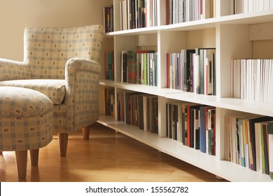 Home library with arm chair. Clean and modern decoration.