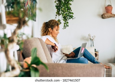 Home Lifestyle Real Scene With People And Technology .- Beautiful Woman Sit Down On The Sofa And Use Laptop Computer And Connection For Work Or Look For The Web - Female Caucasian And Smart Working