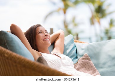 Home lifestyle woman relaxing enjoying luxury sofa patio furniture on outdoor patio living room. Happy lady lying down on comfortable pillows daydreaming thinking. Beautiful young Asian chinese girl. - Shutterstock ID 504293641