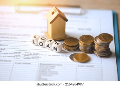 Home loan concept, Loan application form paper with money coin and loan house model on table, Loan business finance economy commercial real estate investments concept