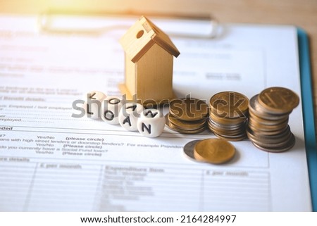 Home loan concept, Loan application form paper with money coin and loan house model on table, Loan business finance economy commercial real estate investments concept