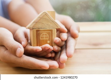 Home loan, home insurance, family life assurance protection, financial mortgage for house building, and legacy planning investment concept with children - parent's hands holding private property - Shutterstock ID 1241980270