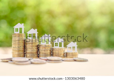 Home loan / reverse mortgage, asset refinancing concept : Small house or home on stacks of coins, depicts a homeowner or a borrower turns properties into cash, saving money to buy shelter, basic need