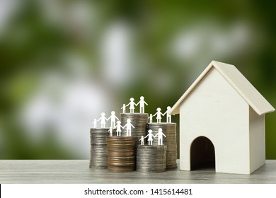 Home Loans, Cheap Home Projects, First Homes To Start A Family Concept. Family Member On Stacked Coins With Small Wooden House. Depicts No Need To Have A Lot Of Money To Be Able To Have A House.