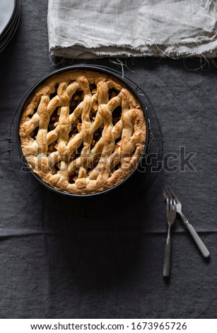 Home made applepie in black baking mold on linen with two forks