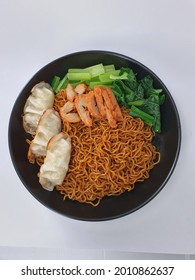 home made black soya sauce noodle with vegetarian meat, dumpling and vegetable, isolated in white background.