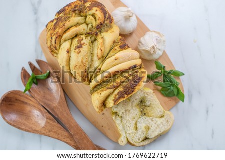 home made braided basil pesto bread on a table