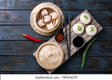 Home made chinese dumplings served on the traditional steamer decorated with sweet chili sauce, fresh chillies and bok choi. Top View - Shutterstock ID 749476279