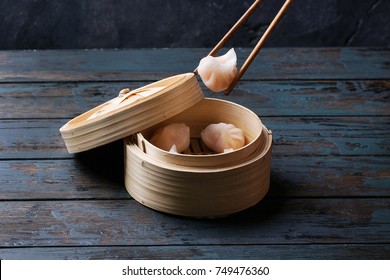 Home made chinese dumplings served on the traditional steamer over blue wooden background. Top View - Powered by Shutterstock