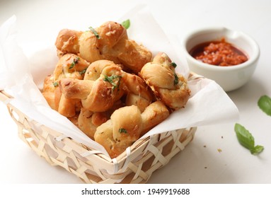 Home made garlic knots - strips of pizza dough tied in a knot, baked and then topped with melted butter, garlic and parsley. Served with marinara sauce