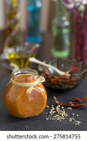 Home Made Hot Chilly Harissa Paste In A Glass Jar With Colorful Background