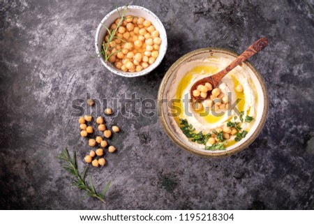 Home made hummus bowl, decorated with boiled chickpeas, herbs and olive oil over a rustic metal background. Top View. Stok fotoğraf © 