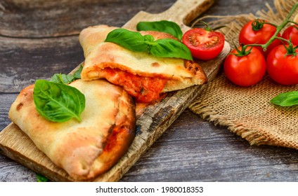 Home made italian calzone vegetarian  pizza with  tomatoes, mozzarella and parmesan cheese and fresh basil 