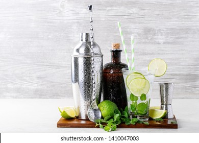 Home Made Mojito Cocktail Decorated With Lime, Mint Leaves, Ice Cubes And Silver Shaker Over White Bright Background