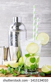 Home Made Mojito Cocktail Decorated With Lime, Mint Leaves, Ice Cubes And Silver Shaker Over White Bright Background