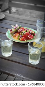 Home Made Organic Chicken And Pepper Skewers With Mexican Marinade And Home Margarita Cocktail In A Glass Jug On A Garden Table  