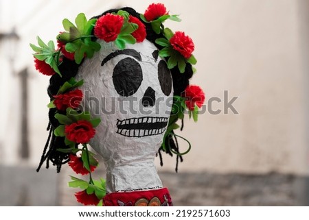 Home made paper mache Mexican style skeleton doll head adornate with red roses.
