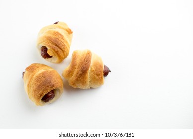 Home Made Pigs In A Blanket. Sausages Rolled In Croissant Dough Baked And Placed On White Background.
