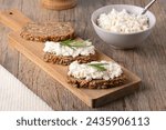 Home made rye bread on a wooden cutting board with curd cheese