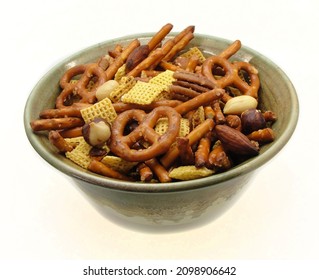 Home Made Square Cereal And Pretzel Snack Mix In An Artisan Pottery Bowl Isolated On White