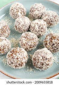 Home Made Vegan Energy Protein Balls With Coconut Flakes, Almond Butter, Oats, Nuts, Dates, Dried Fruit, Flax And Hemp Seeds Served On White Wooden Board.