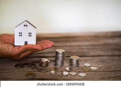 Home Model On The Stacked Coin With Many Increase And Grow Value In The Public Park, Financial Of Real Estate Business Investment And Save Money For Buy House Concept.