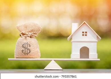 Home and money bag put on the scales with balance put on the wood in the public park, Saving for buy a new house or real estate and loan for plan business investment in the future concept. - Shutterstock ID 793357861