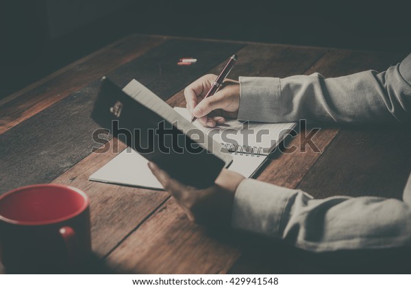 home office desk background, Desk musicians, hand\
holding pencil and writing note on wood table,Checklist Notice\
Remember Planning Concept