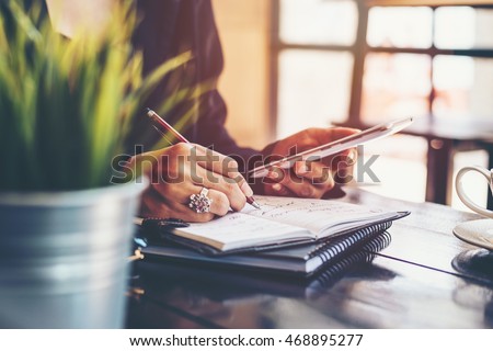 home office desk background,hand holding pencil and writing note on wood table,Checklist Notice Remember Planning Concept